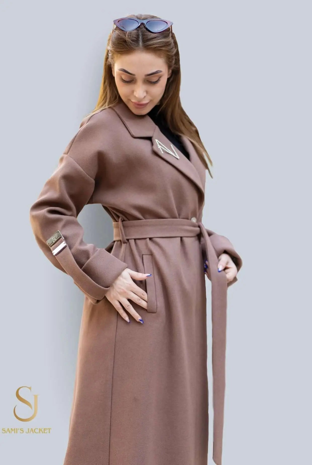 Stylish women's winter coat in brown, featuring a belted waist and elegant design, perfect for cold weather fashion.