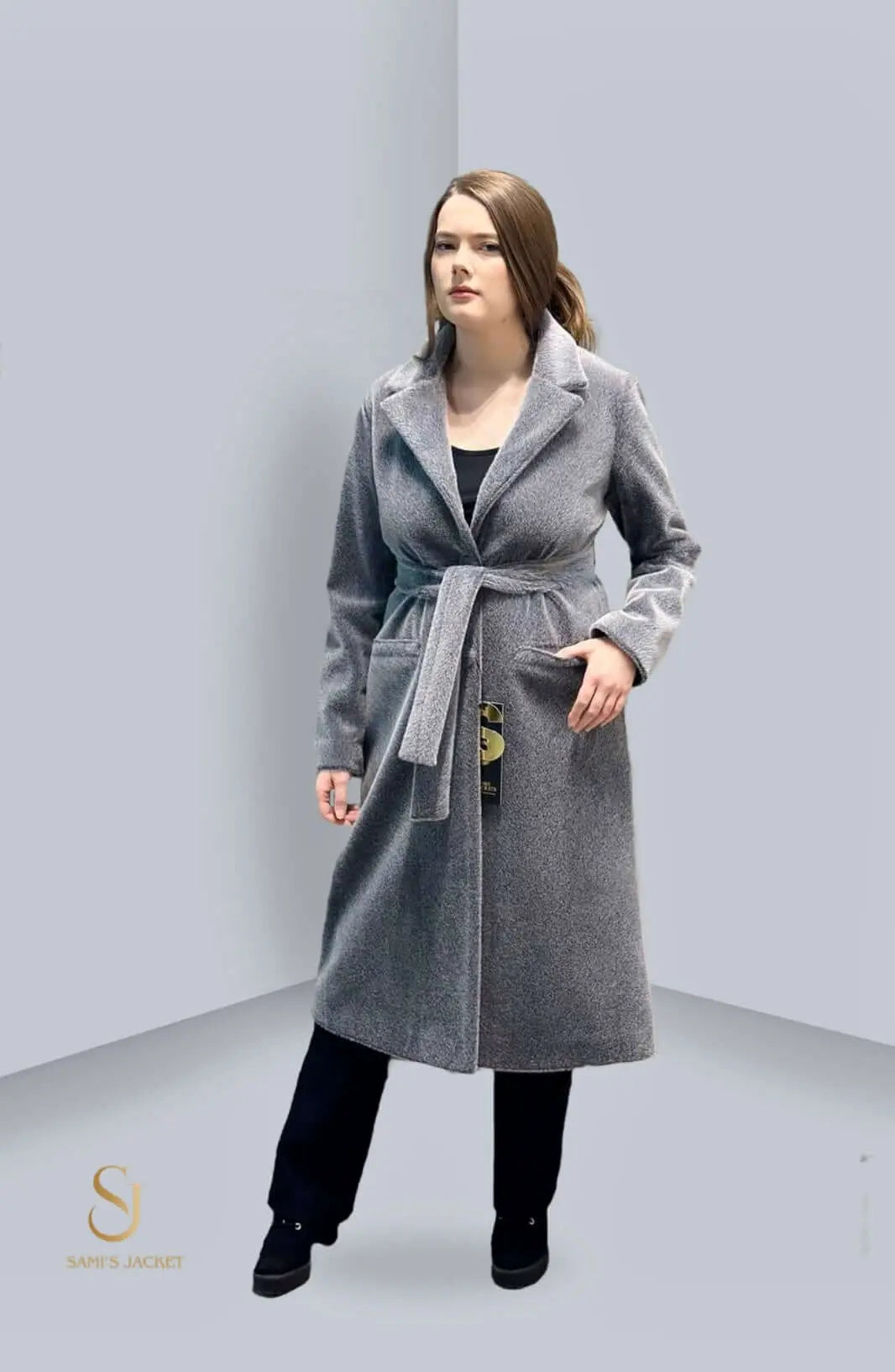 Stylish woman in a grey winter coat with a belt, showcasing modern design and warmth for cold weather.