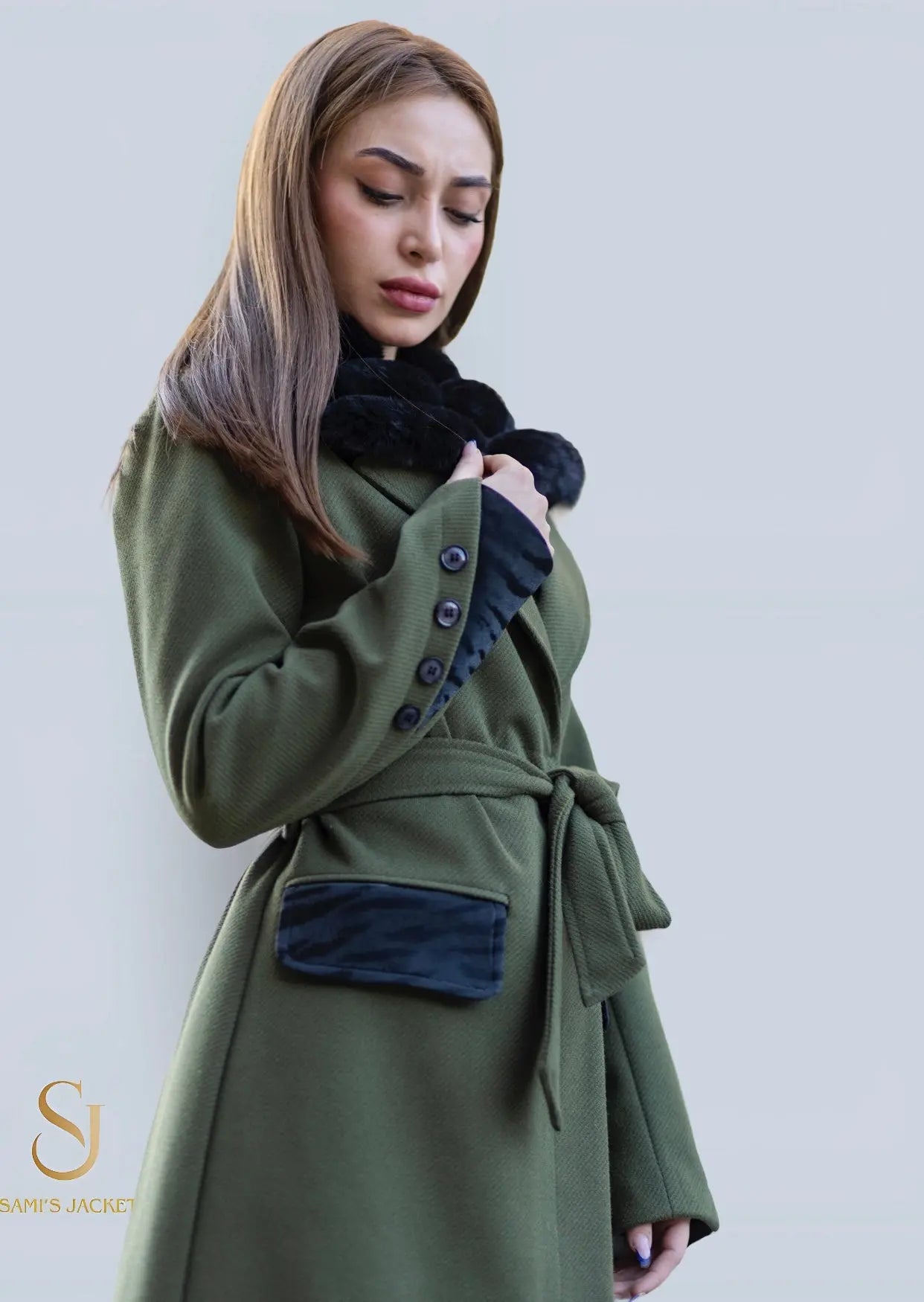 Elegant woman wearing a stylish green winter coat with a tie waist and black accents, perfect for cold weather.